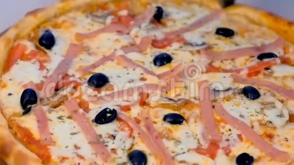 厨师在桌子上的木板上用培根和奶酪切比萨饼特写镜头视频的预览图