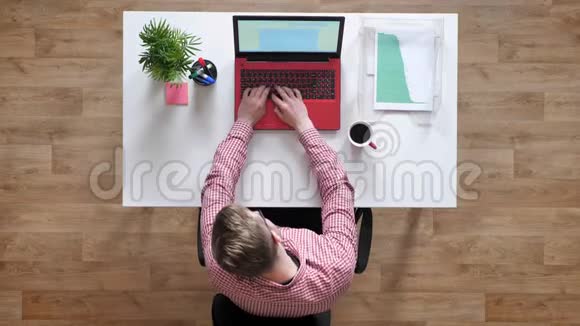 戴眼镜的年轻人在笔记本电脑上打字打电话女人给他文件顶头坐在桌子后面视频的预览图
