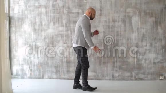 男人在灰色背景下跳舞疯狂快乐的商人穿着一套西装跳舞庆祝成就肖像视频的预览图