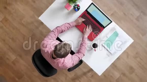 戴眼镜的年轻人在笔记本电脑上打字人们四处走动顶着头坐在桌子后面忙着绕着视线转视频的预览图
