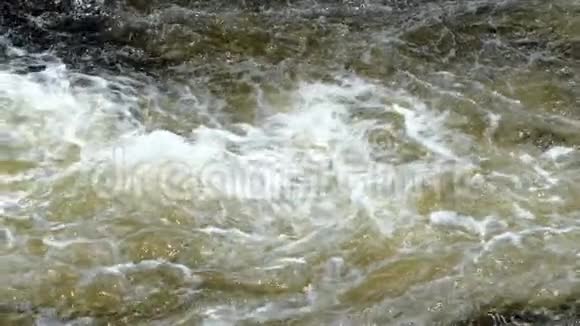 浅的快速流动的水流在淹没的岩石上旋转视频的预览图