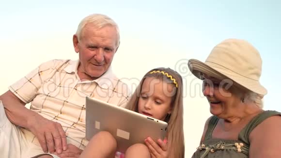 带电脑平板电脑的孙女和惊讶的祖母视频的预览图