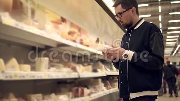 单身男人在超市里拿着奶酪和肉包然后把视频的预览图