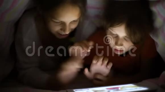 白人女孩晚上在毯子下面玩游戏视频的预览图