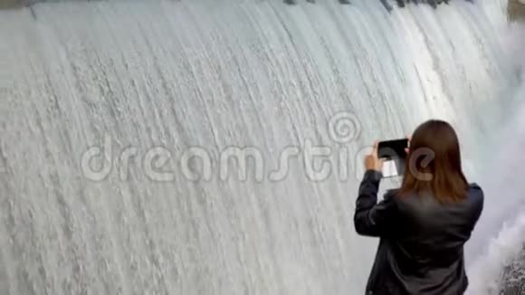 女孩正在拍一张照片水是如何掉进瀑布的视频的预览图