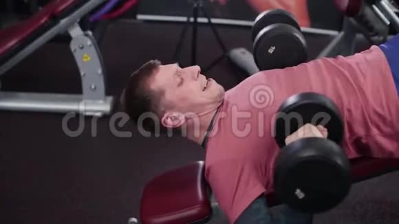 运动和有魅力的男人在健身房做哑铃凳视频的预览图