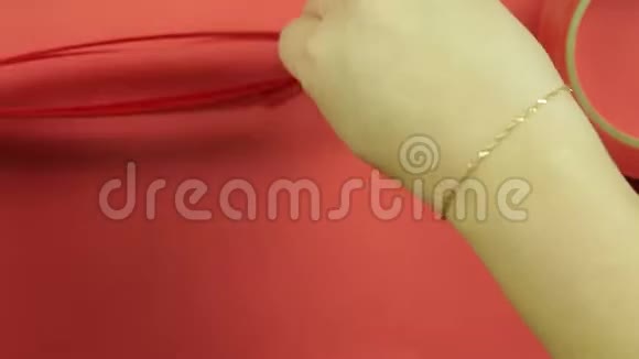 女人手塑造红色丝带空白做礼物鞠躬红色背景视频的预览图