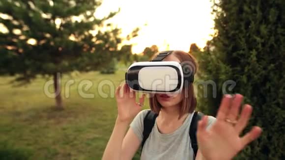 女人在花园里用虚拟现实眼镜晚上好视频的预览图