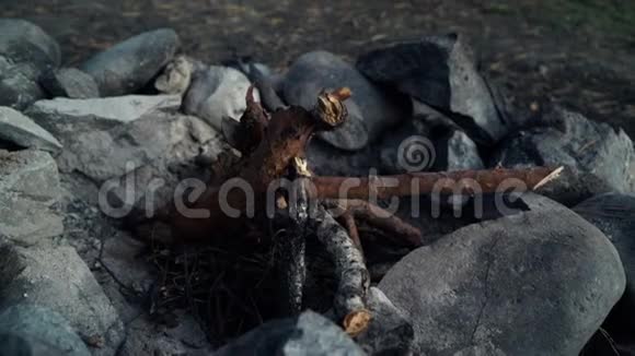 一位游客晚上在燧石旁的一块石头上生火近距离手臂视频的预览图