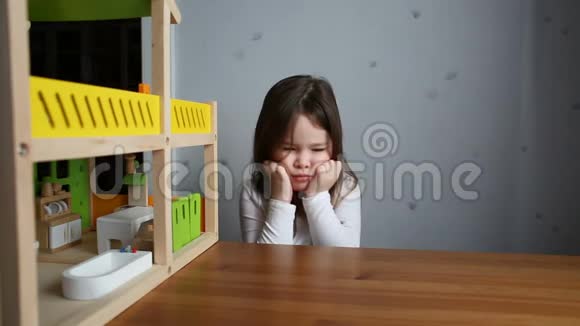 一个可爱的女孩在玩娃娃屋时感到困倦视频的预览图
