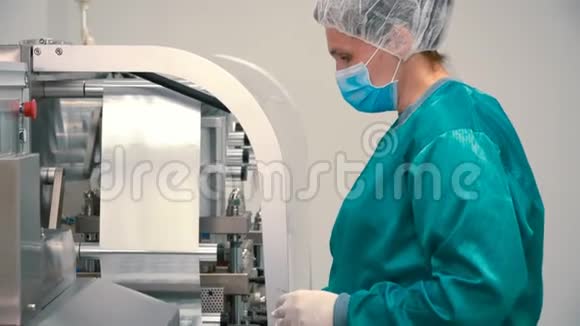 工作人员戴口罩和防护制服控制分拣胶囊的过程视频的预览图
