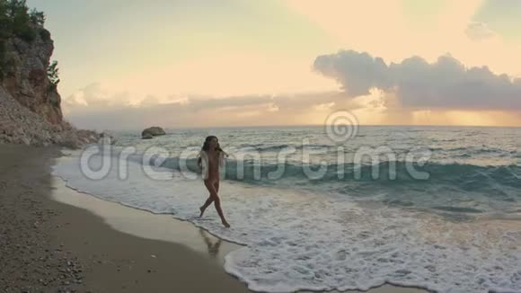 年轻漂亮的女人在海滩上慢跑视频的预览图