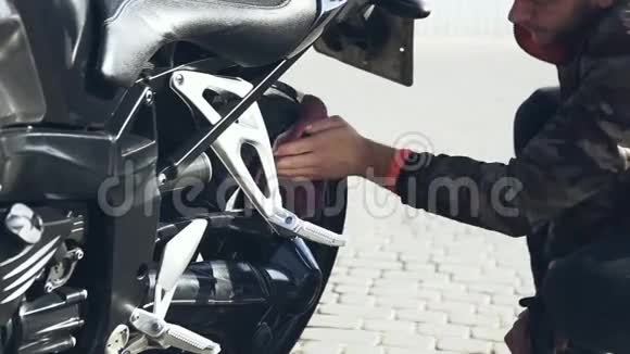 一个男人在洗衣机上用布擦摩托车视频的预览图