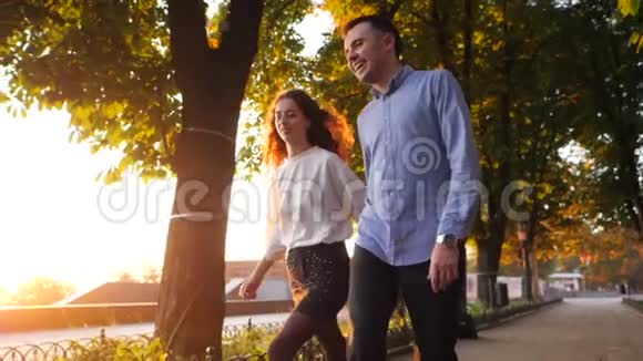 一对男女牵着手在秋城公园奔跑时髦的一对或穿商务服装的学生乐意视频的预览图