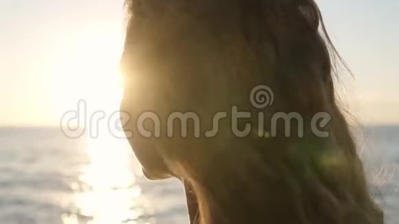 一个年轻的黑发女人站在阳光下的美丽肖像沉思地看着享受着夏天视频的预览图