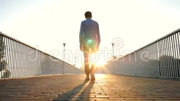 年轻英俊的商人或学生独自走在空桥或街道上后景环游世界成功视频的预览图