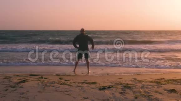 健身男子训练斜坡练习海岸和海浪背景视频的预览图