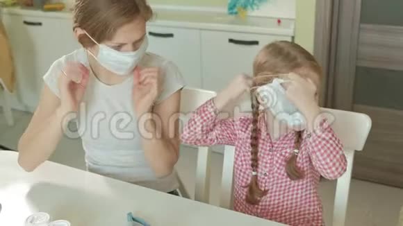 年轻妇女和女孩戴上医疗面具母女视频的预览图