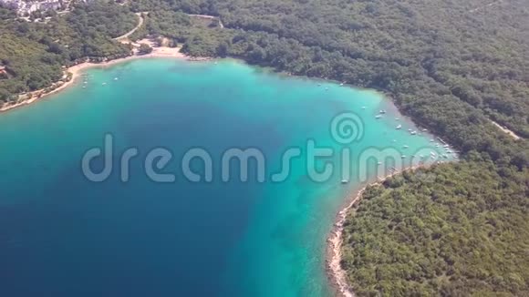 克罗地亚Krk船在岛上海岸线上的空中俯瞰清澈的海水视频的预览图