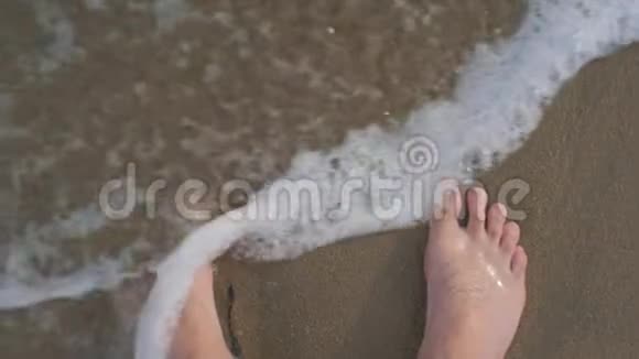 人光着脚在沙滩上进入海浪的视角视频的预览图