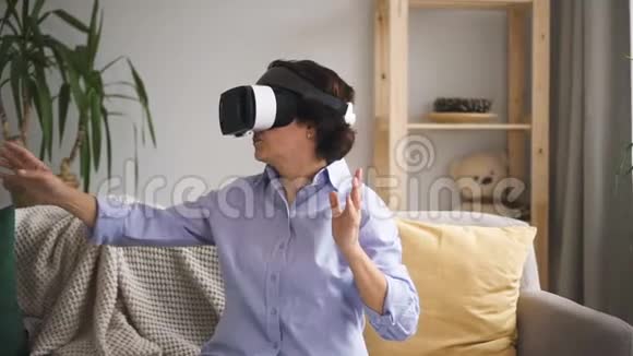 成熟的女人在说话在公寓内部测试虚拟现实眼镜视频的预览图