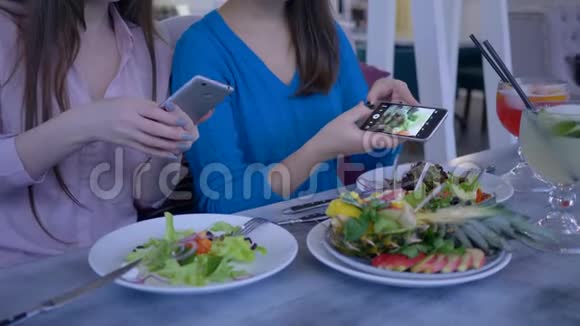 在博客上女性朋友的手在节食期间用手机拍下早餐时漂亮有用的食物视频的预览图