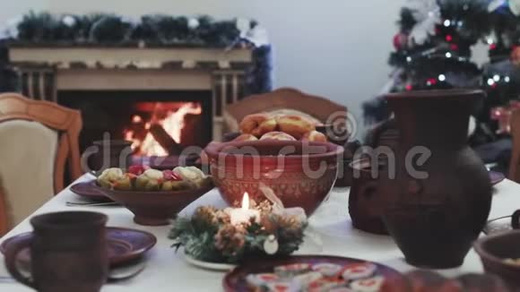 圣诞节和寒假的晚餐烛光放在木制桌子上上面有圣诞装饰圣诞树和圣诞树视频的预览图