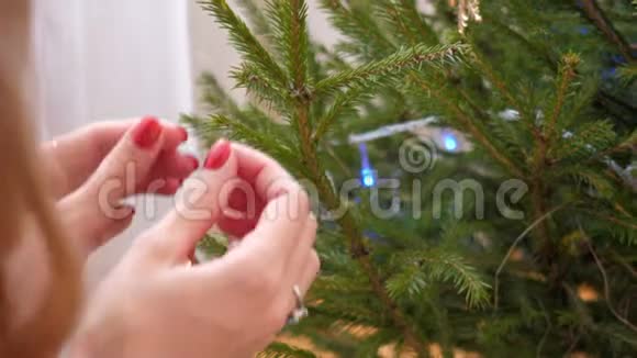 慢动作特写双手将金锥挂在圣诞树上视频的预览图