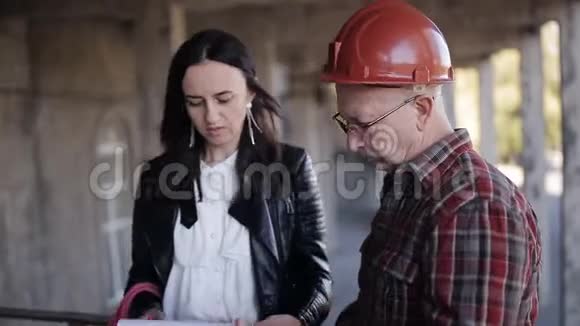 女工程师和主管在头盔讨论必要的材料和技术资源以继续视频的预览图