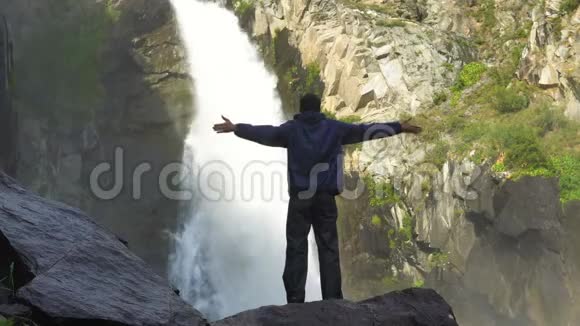 一个旅行者站在瀑布前视频的预览图
