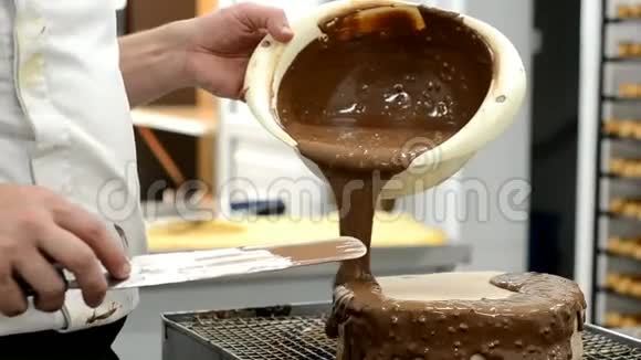 专业糕点厨师在蛋糕上倒入融化的巧克力糖果和甜点视频的预览图