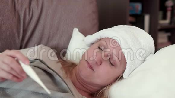 一个中年妇女躺在沙发上她感冒了头痛视频的预览图