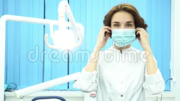 一位牙医戴上面具在牙科诊所看相机的肖像女牙医助理视频的预览图
