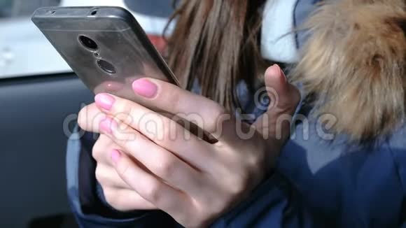 有手机的女人在车里特写女人手在电话里聊天视频的预览图