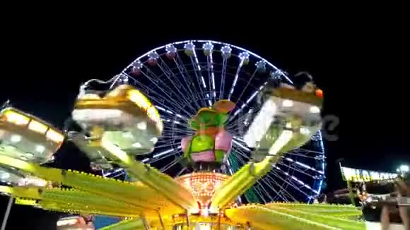 明亮的摩天轮在狂欢节游乐园主题公园集市刺激公园晚上旋转视频的预览图