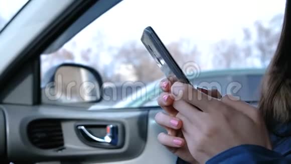 有手机的女人在车里特写女人手在电话里聊天视频的预览图