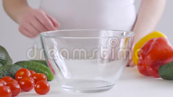 厨房餐桌上的一位女士把樱桃番茄放在一个堆叠的碗里视频的预览图