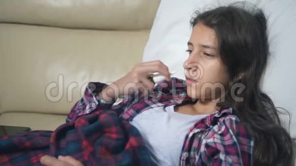 十几岁的女孩感冒了吹着鼻子躺在被子下面的沙发上视频的预览图