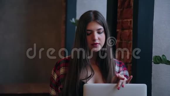 漂亮迷人的商务女性在餐桌旁的咖啡馆工作后关闭了笔记本电脑视频的预览图