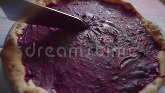 家庭主妇在厨房用刀切浆果派甜糕点开放的浆果派传统的美国派视频的预览图