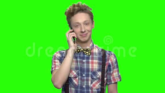 穿着格子衬衫的少年用电话说话视频的预览图