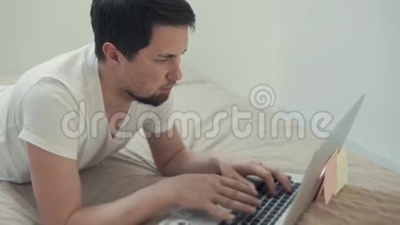 一个年轻人在笔记本电脑前休息他坐在社交网络中视频的预览图