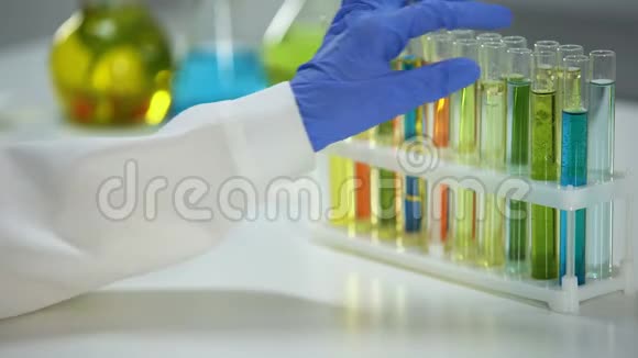 实验室助理用蓝色液体检查管子中的沉淀物洗涤物视频的预览图