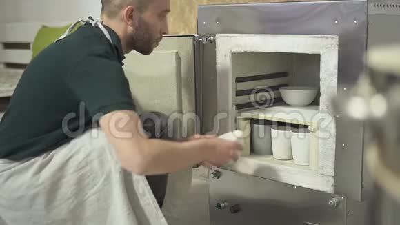 在陶器车间里人们把陶罐放在烤箱里烧制视频的预览图