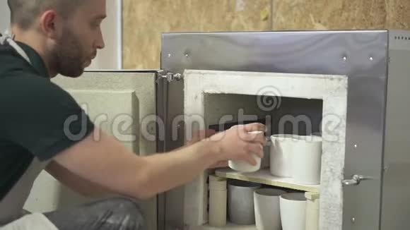 少爷正在烤箱制陶车间摆放粘土制品视频的预览图