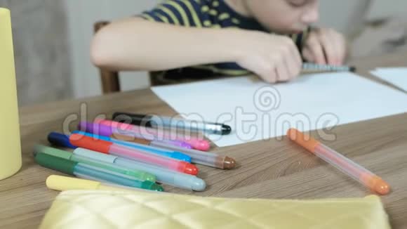 7岁的男孩穿着条纹t恤用铅笔和尺子在纸上画均匀的线条布鲁尔视频的预览图