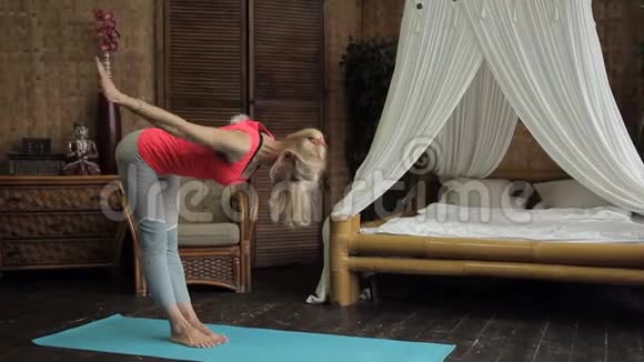 有魅力的女人正在公寓里练习瑜伽姿势视频的预览图