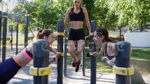 三个有魅力的女孩在公园里玩铁模拟器运动视频的预览图