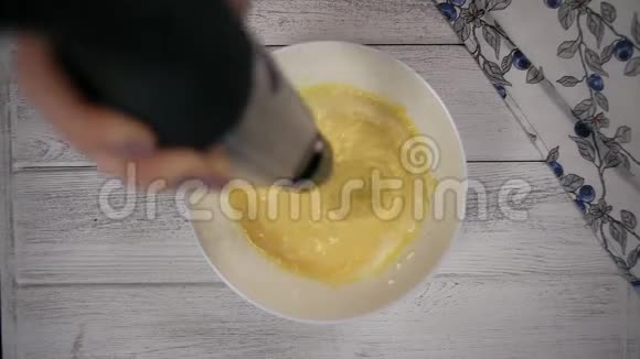 顶部景观厨房搅拌机搅拌蛋黄和蛋白质在白碗视频的预览图