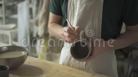 在陶器上主人做笔记把手柄连接到杯子上视频的预览图
